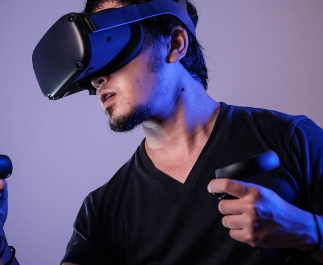 Person wearing a VR headset with motion controllers in a VR headset for beginners guide