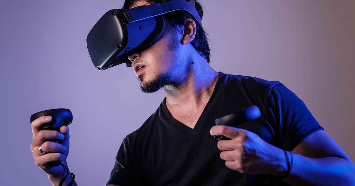 Person wearing a VR headset with motion controllers in a VR headset for beginners guide