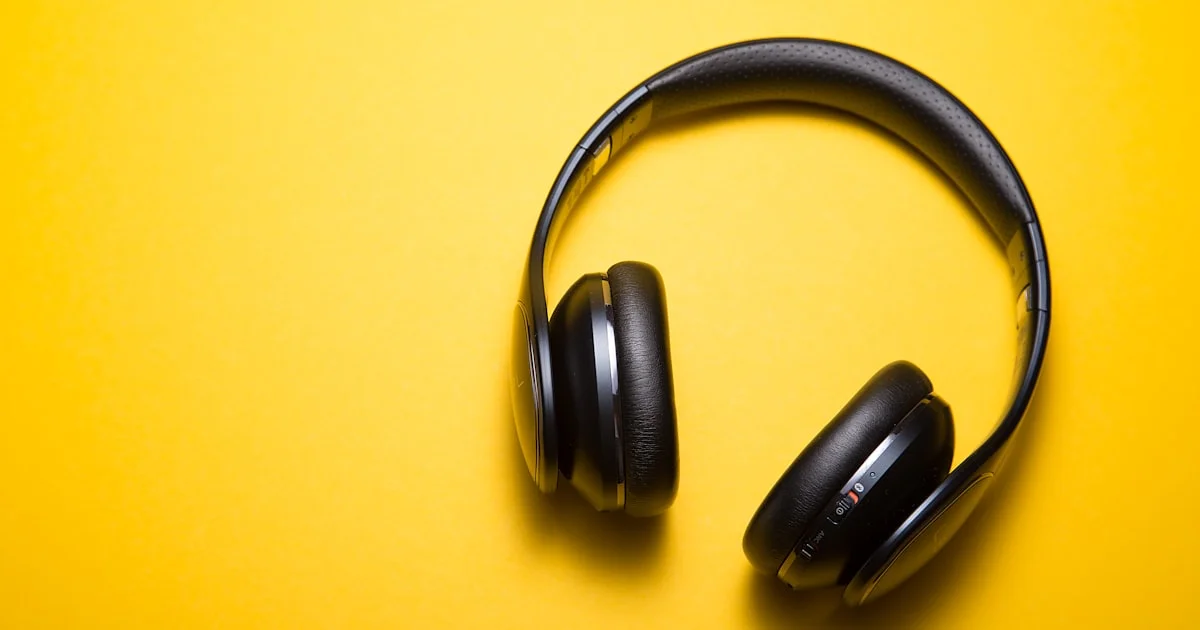 Black over-ear noise cancelling headphones on a yellow background