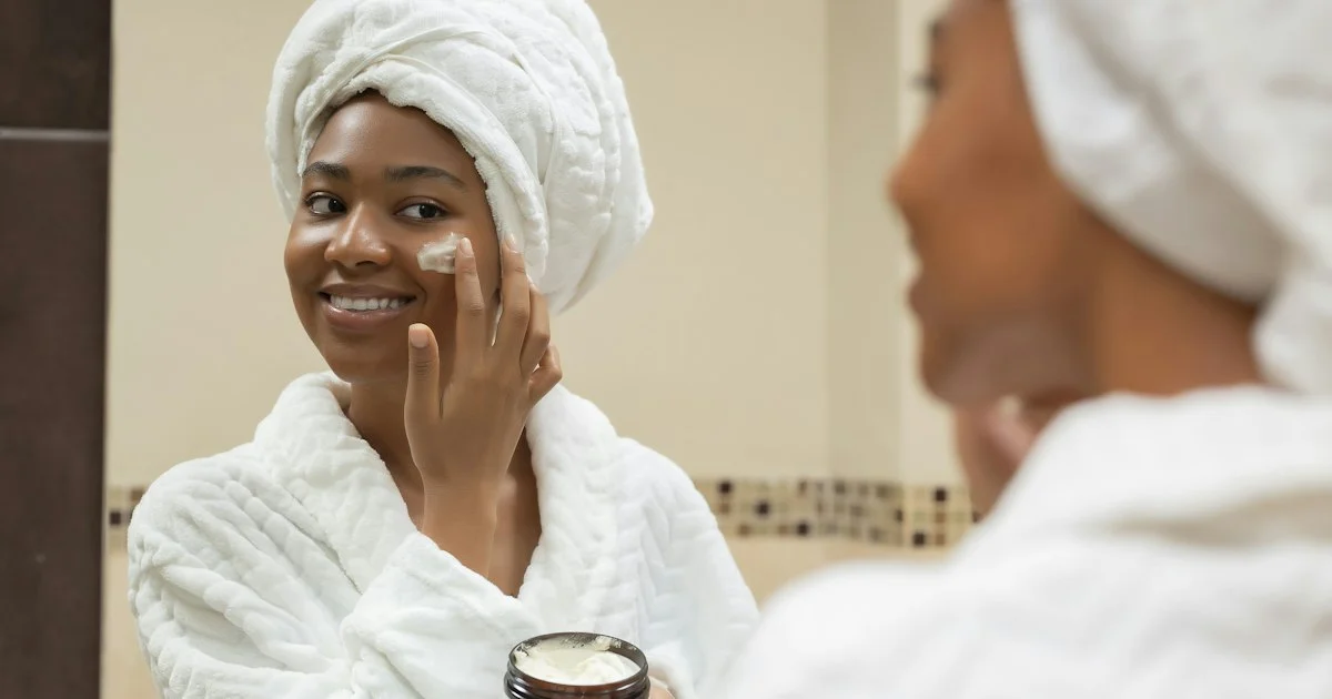 A woman applying cream at a bathroom mirror, the at-home routine around the best derma roller 2026 shoppers are choosing