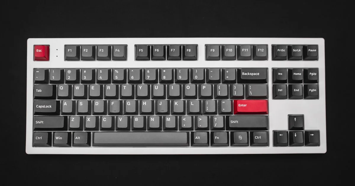 White mechanical keyboard with red accent keys on a dark background