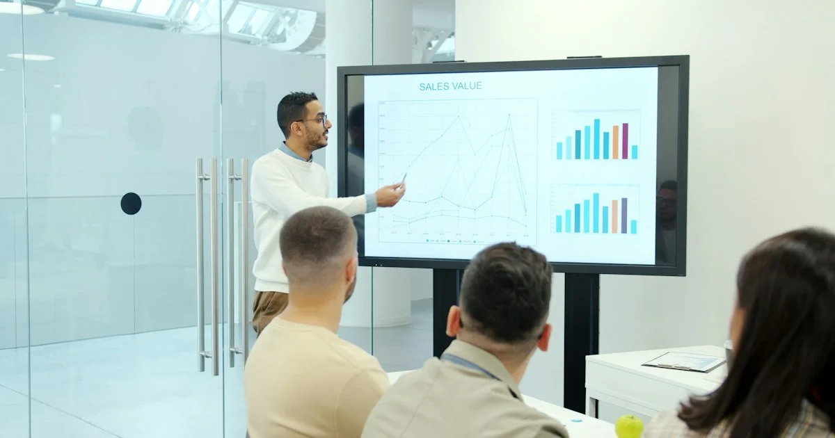A presenter touching a large interactive display on a rolling stand, the setup to weigh when working out how to buy a smart board