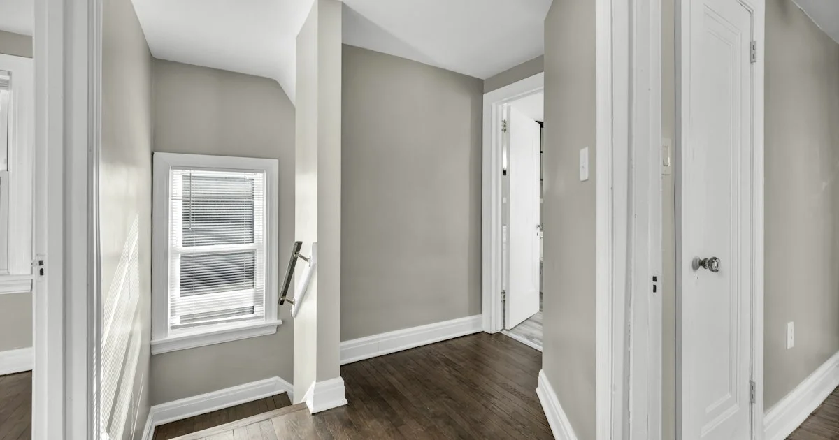 An upstairs hallway with bedroom doors and a window, the placement that decides how to buy a smart smoke detector and how many are needed