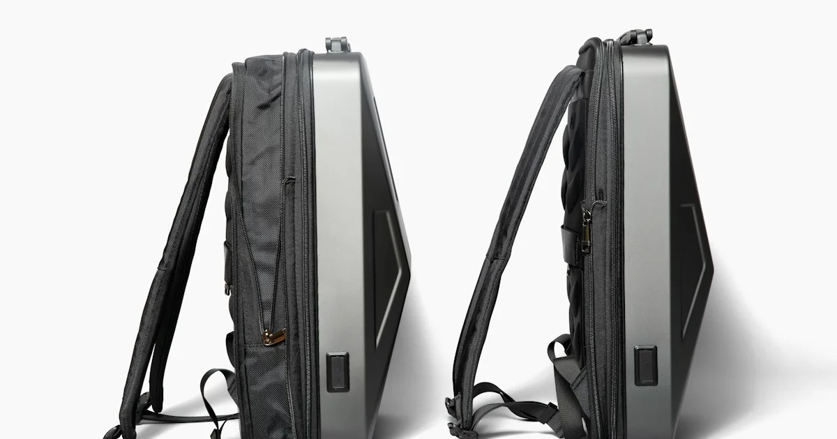 A hard-shell commuter backpack shown from both sides with a small external port, the shape behind how to choose a smart backpack