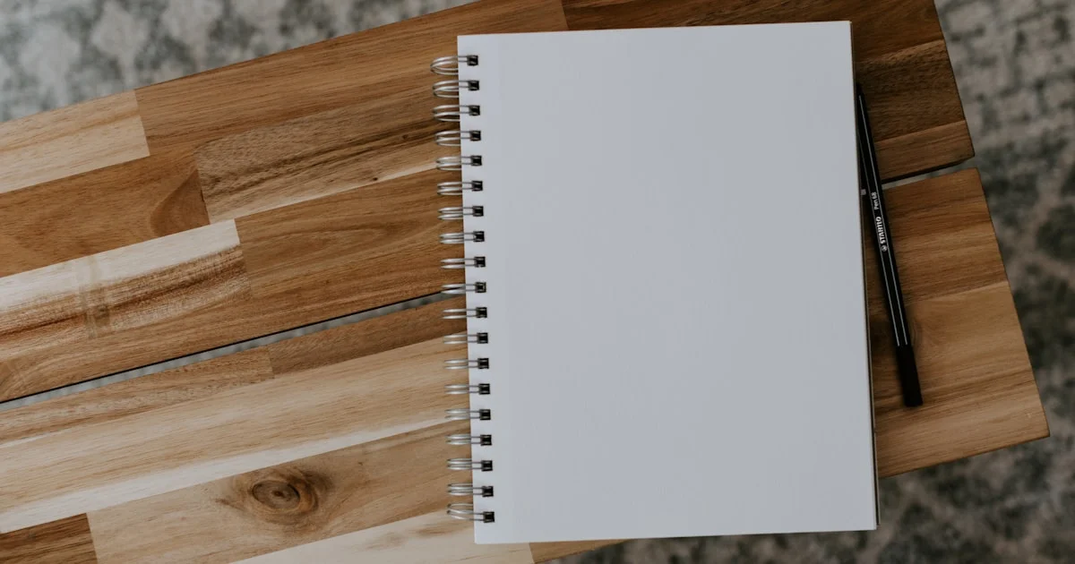 Spiral-bound reusable smart notebook resting closed on a wooden desk