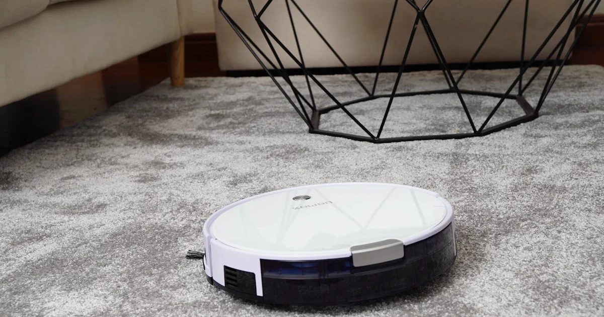 White robot vacuum cleaner on a gray area rug
