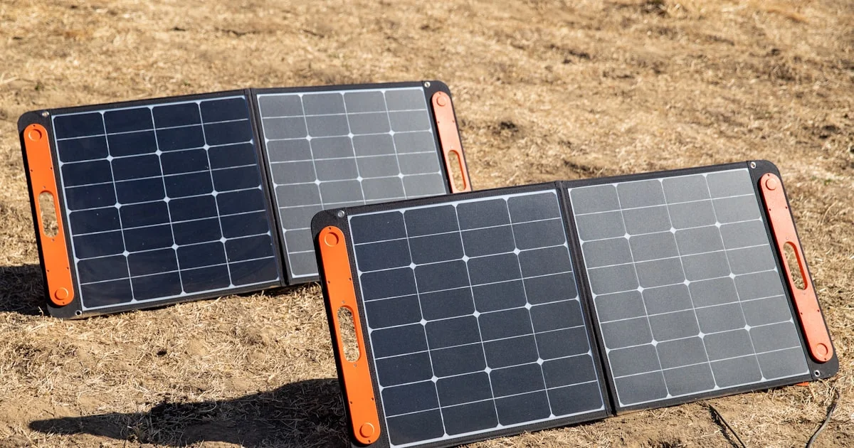 Portable solar power bank panels unfolded outdoors on the ground for charging during a hike