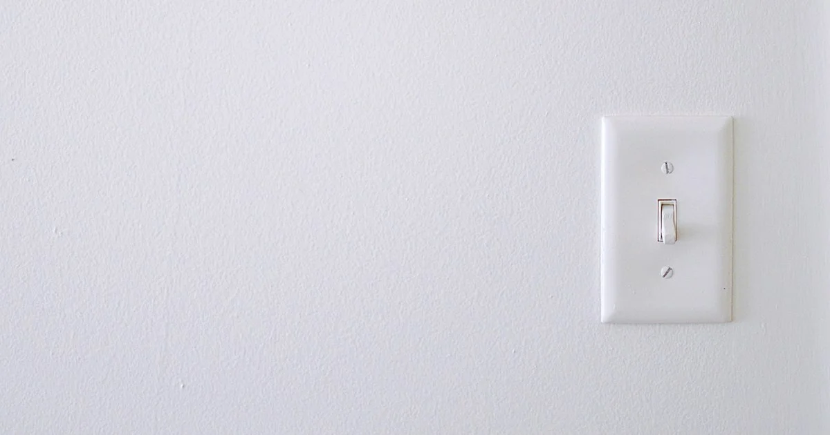 A standard single-pole toggle switch on a plain white wall, the fixture replaced when installing the top smart light switch 2026 shoppers are choosing