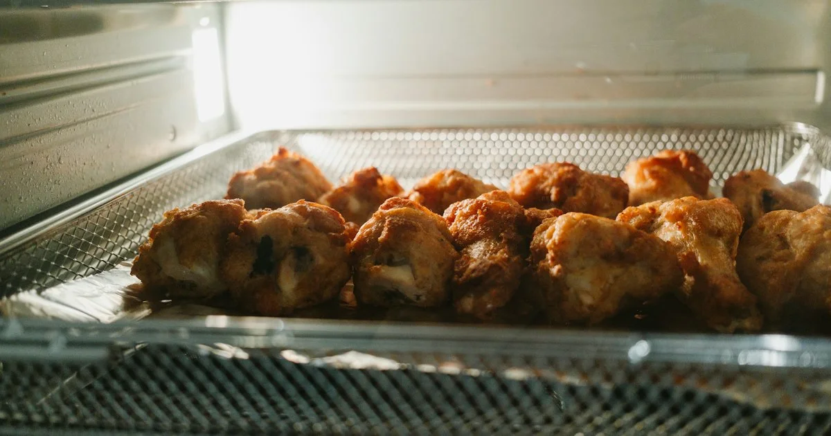 Breaded food in a single layer on a perforated crisper tray inside a hot-air appliance, the basket area that decides a top Walmart air fryer 2026 choice